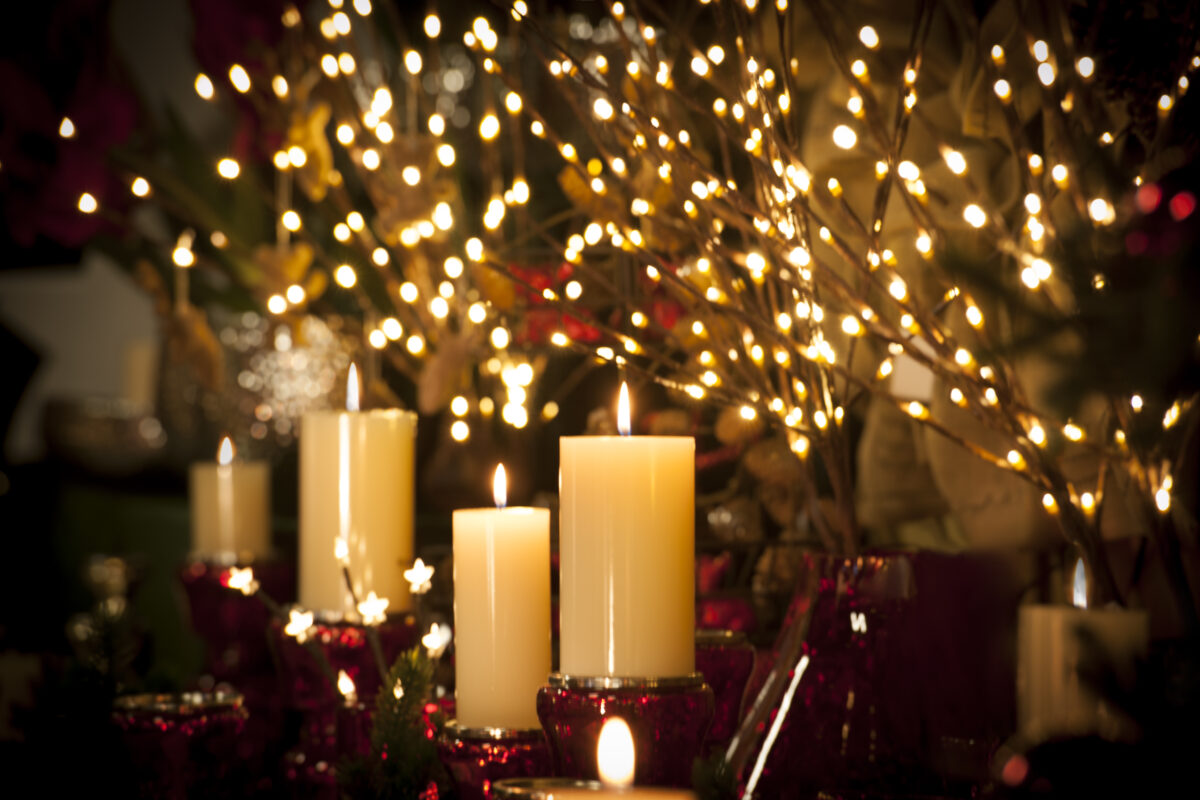 Weihnachtliche Dekoration - weiße Kerzen auf roten Kerzenhalter