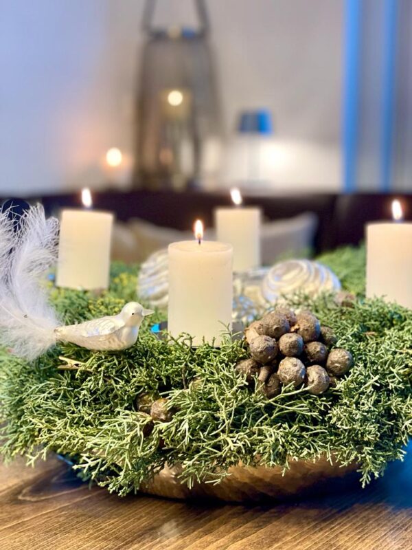 Nobiliskranz mit weißen brennenden Kerzen, weißer Glasvogel und silberne Kugel