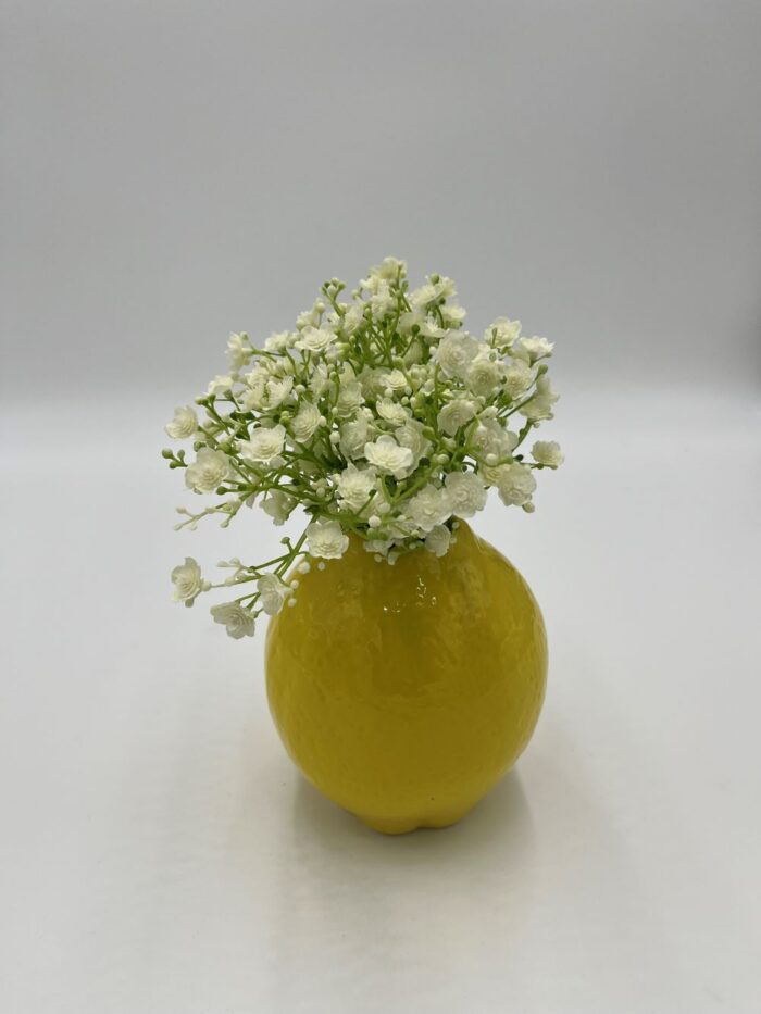 gelbe Vase in Zitronenform mit Schleierkraut