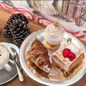 Weihnachtskugeln in Form von Croissant Waffel und Windbeutel auf Teller angerichtet